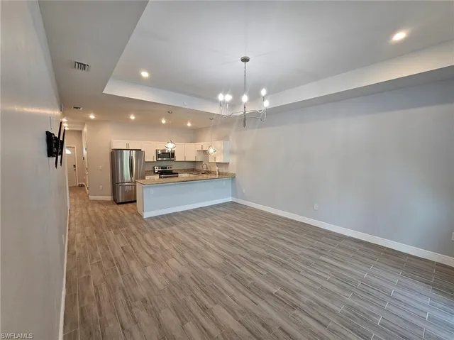 a view of a kitchen with a sink and dishwasher a refrigerator with wooden floor