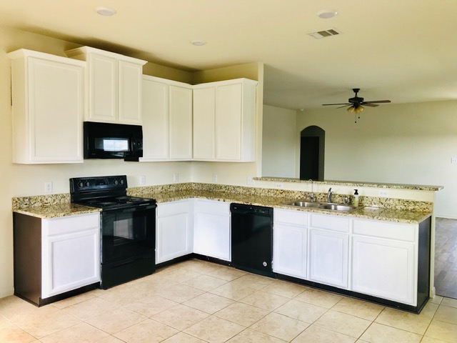 20105 Grover Cleveland Way Manor, TX 78653 - Photo 10 of 17 A well-appointed kitchen features white cabinetry and speckled countertops, offering both style and utility.