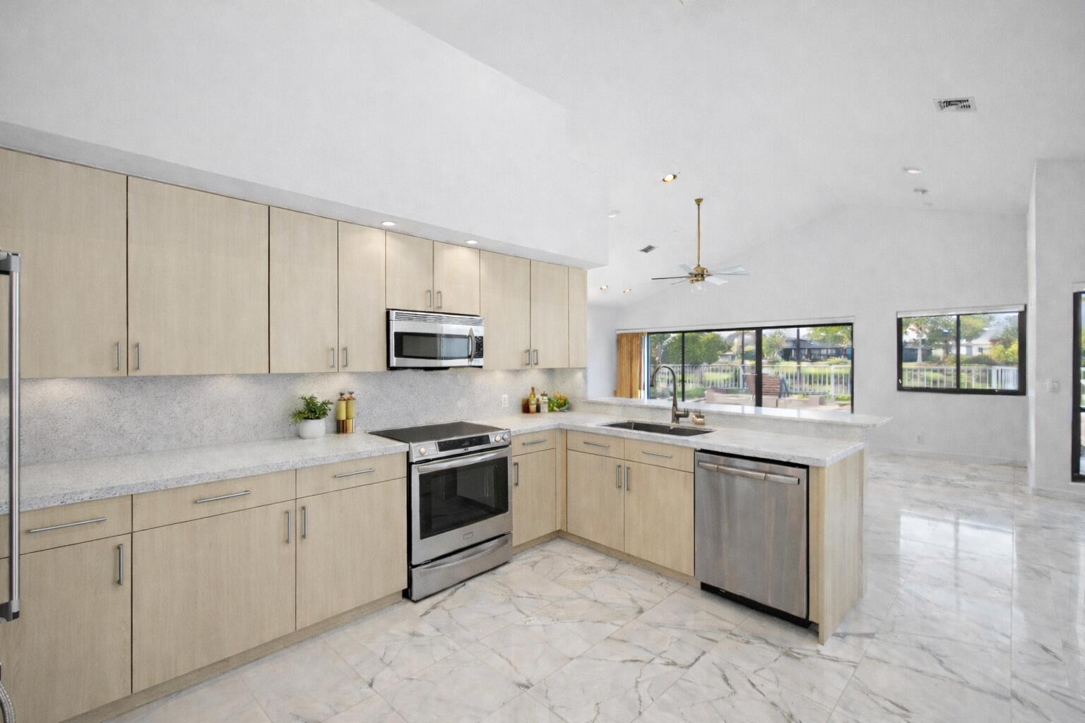 10747 Stonebridge Boulevard Boca Raton, FL 33498 - Photo 4 of 81 a kitchen with white cabinets appliances and a sink