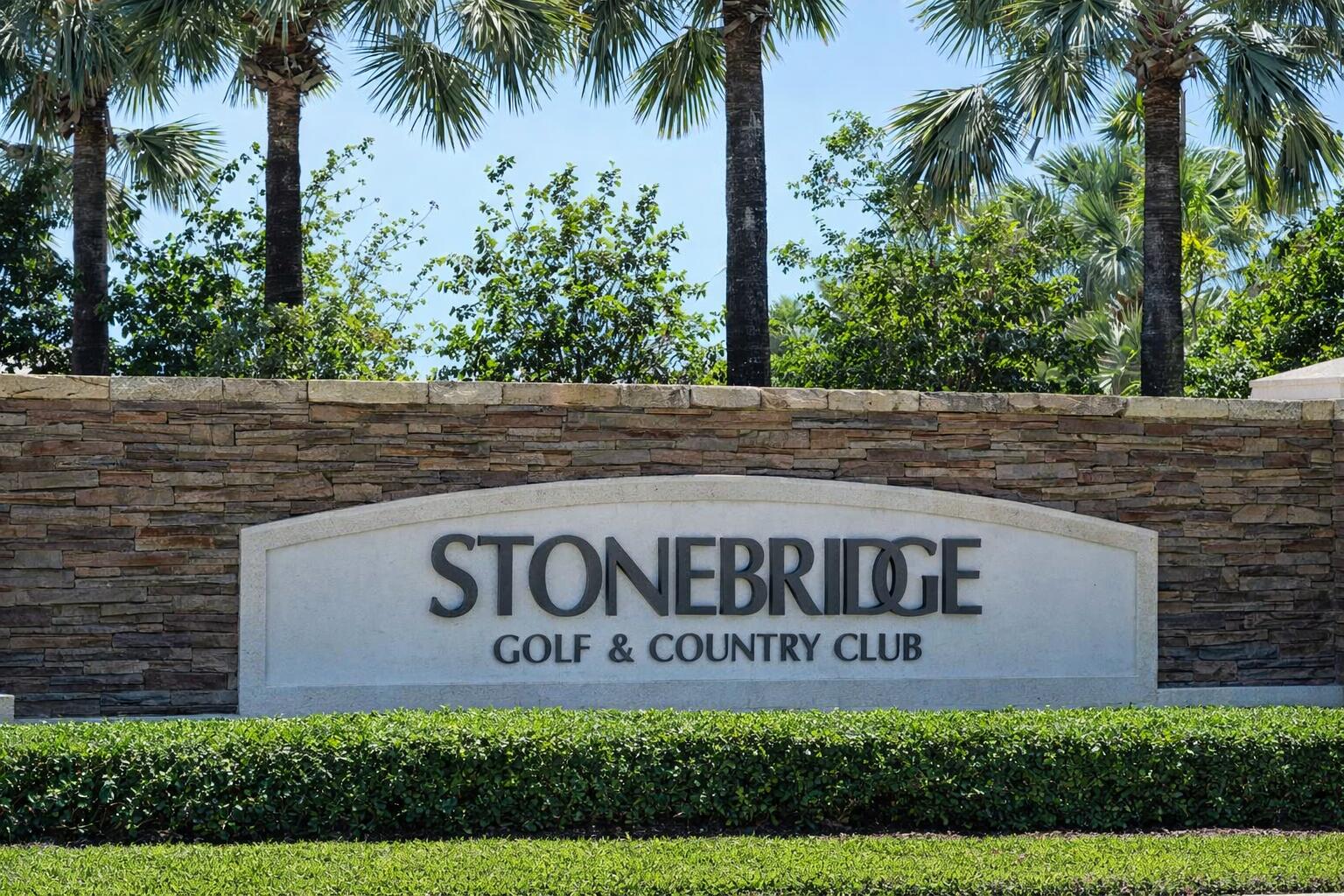 10747 Stonebridge Boulevard Boca Raton, FL 33498 - Photo 81 of 81 a sign of golf club on a wall under a tree