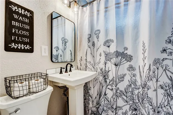 a bathroom with a sink and mirror with bathtub