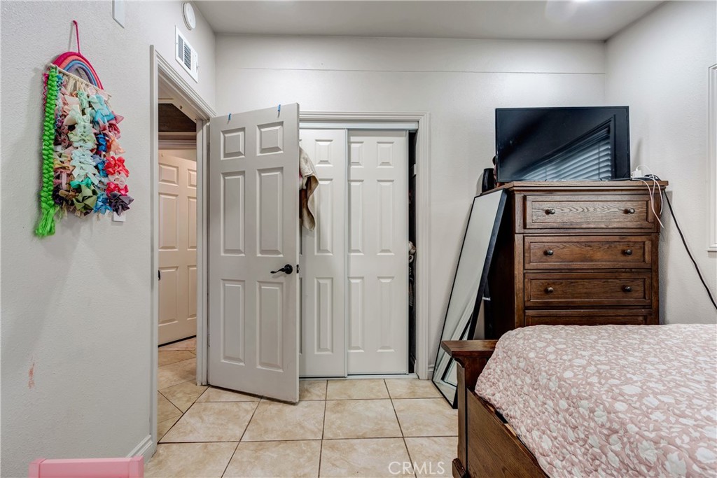 6688 Phoenix Avenue Riverside, CA 92504 - Photo 21 of 26 a bedroom with a bed and a flat tv screen