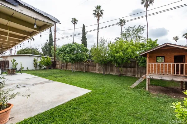 a view of a house with a yard and a fence