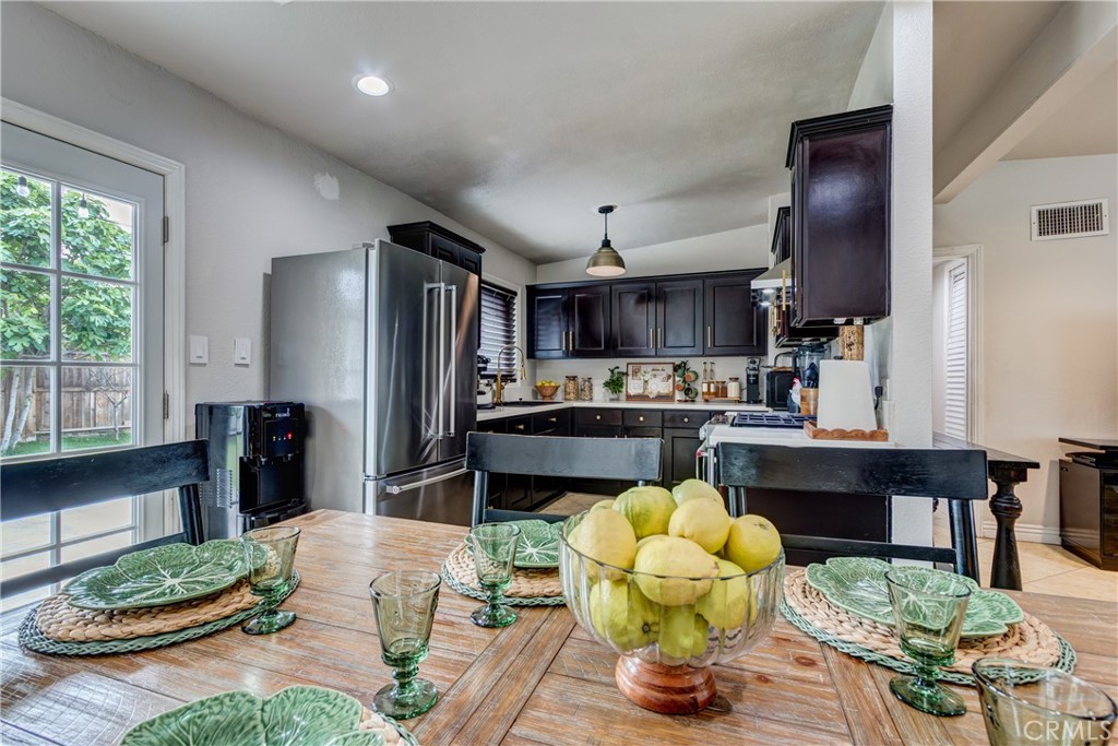 6688 Phoenix Avenue Riverside, CA 92504 - Photo 8 of 26 a kitchen with stainless steel appliances kitchen island granite countertop a refrigerator dining table and chairs