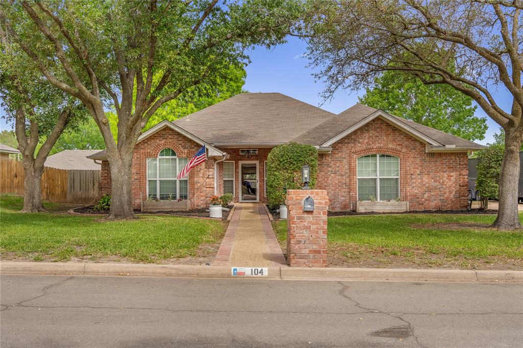 a front view of a house with a garden and yard