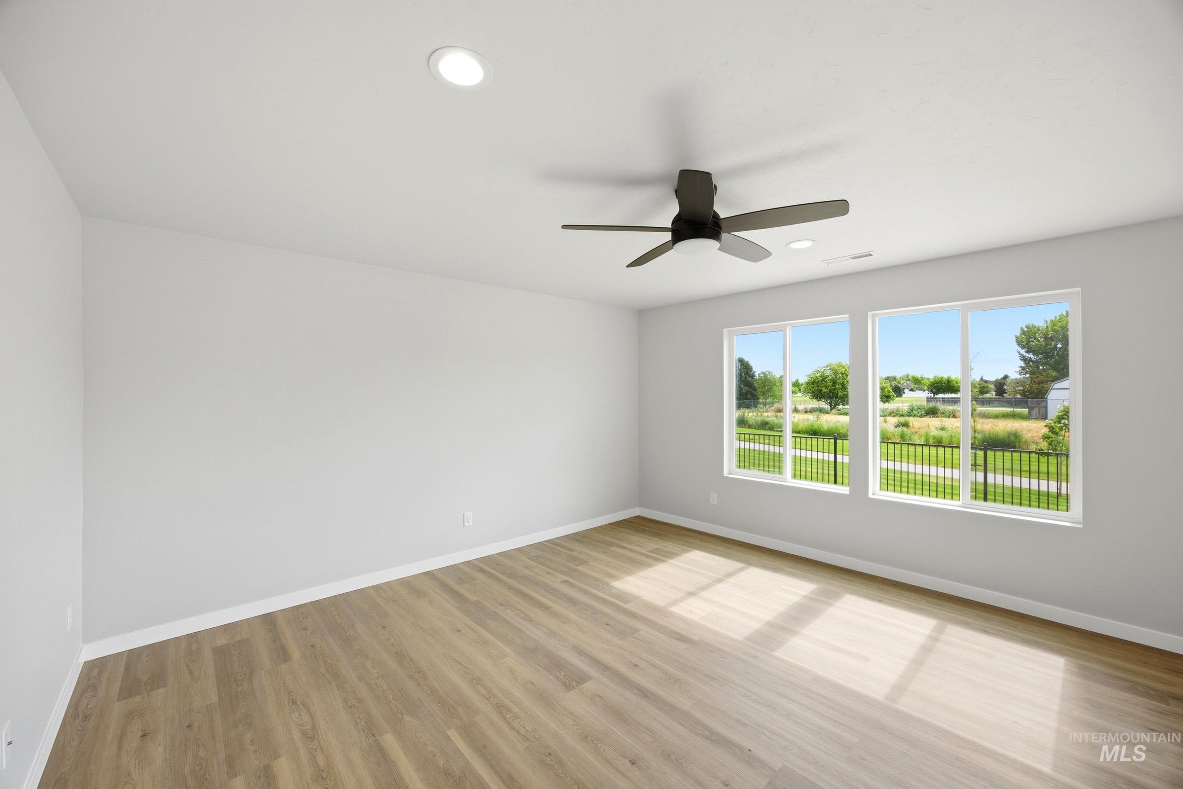 14044 Shiny Spruce Street Caldwell, ID 83607 - Photo 7 of 24 Spacious room featuring wood-finish flooring, two large windows, a ceiling fan, and recessed lighting