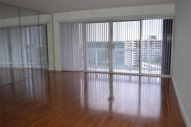 a view of a room with wooden floor and windows