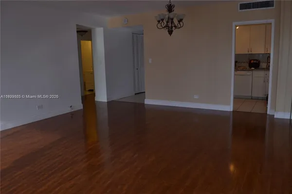 an empty room with wooden floor and closet