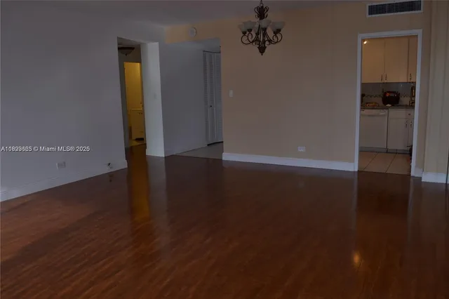 an empty room with wooden floor and closet
