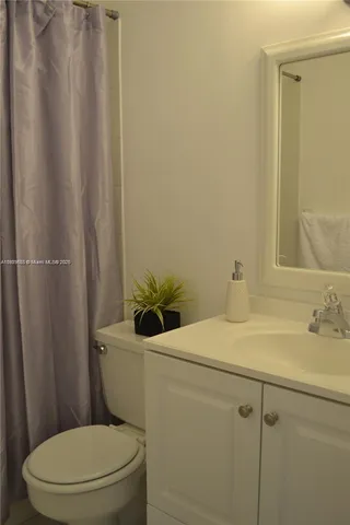 a white toilet sitting next to a bathroom sink