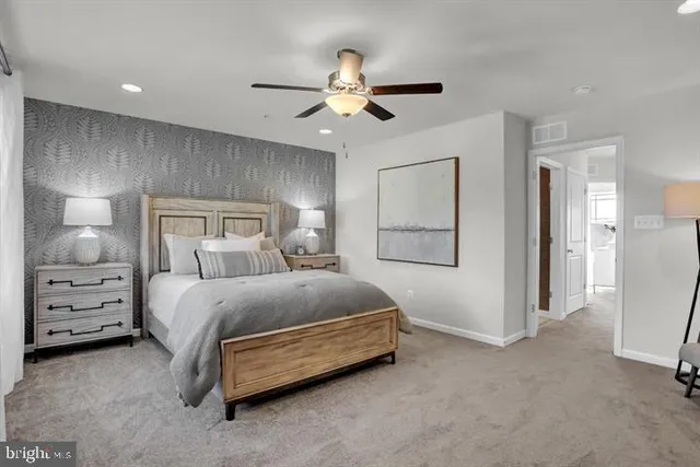 a spacious bedroom with a bed and a ceiling fan