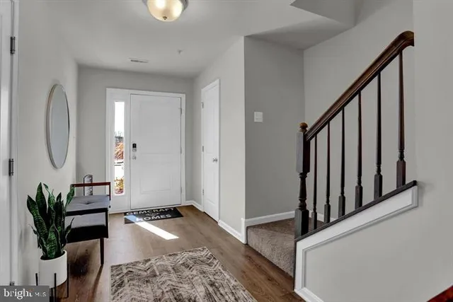 a view of a livingroom with wooden floor and a hallway