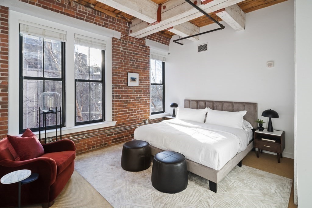 9 West Broadway, Unit 312 Boston, MA 02127 - Photo 12 of 35 a spacious bedroom with a bed and a couch