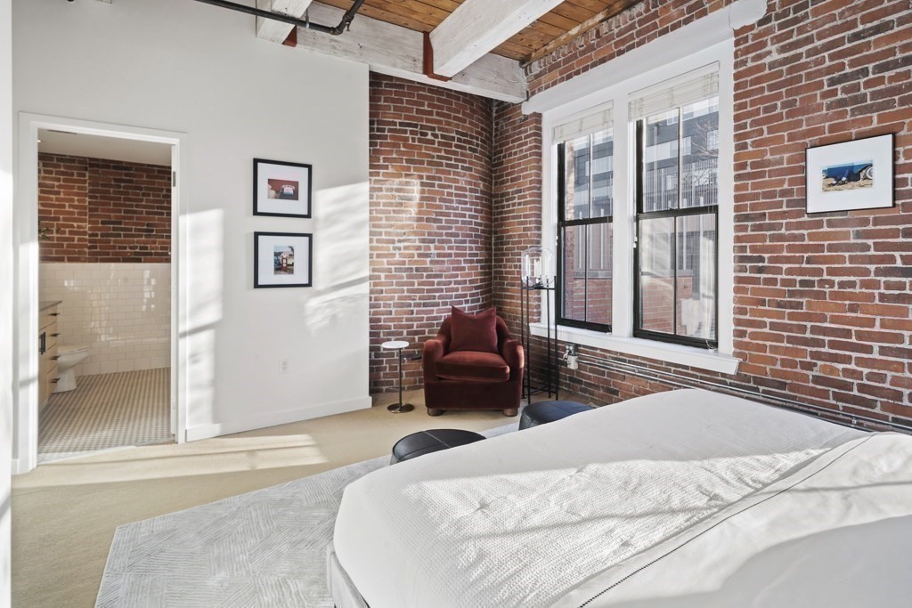 9 West Broadway, Unit 312 Boston, MA 02127 - Photo 14 of 35 a bedroom with a bed and a couch