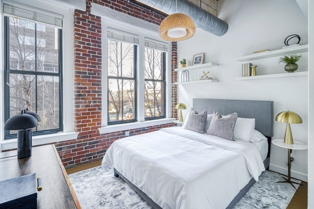 9 West Broadway, Unit 312 Boston, MA 02127 - Photo 18 of 35 a bedroom with a bed lamp and a large window with the outer view