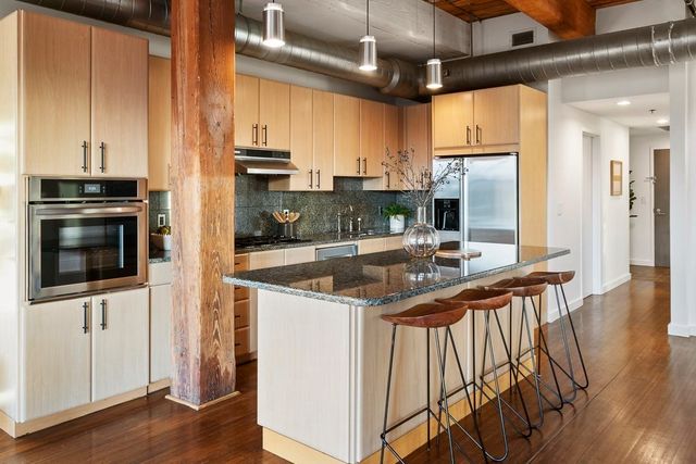 a kitchen with stainless steel appliances granite countertop a stove a sink and a microwave