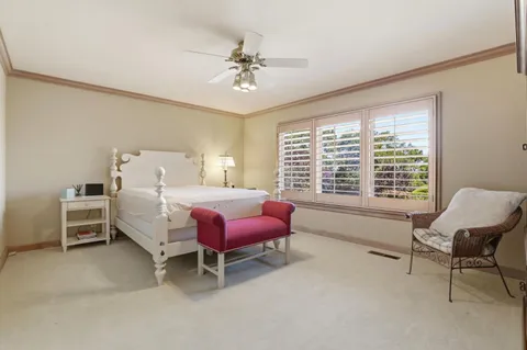 a spacious bedroom with a bed chair and a large window