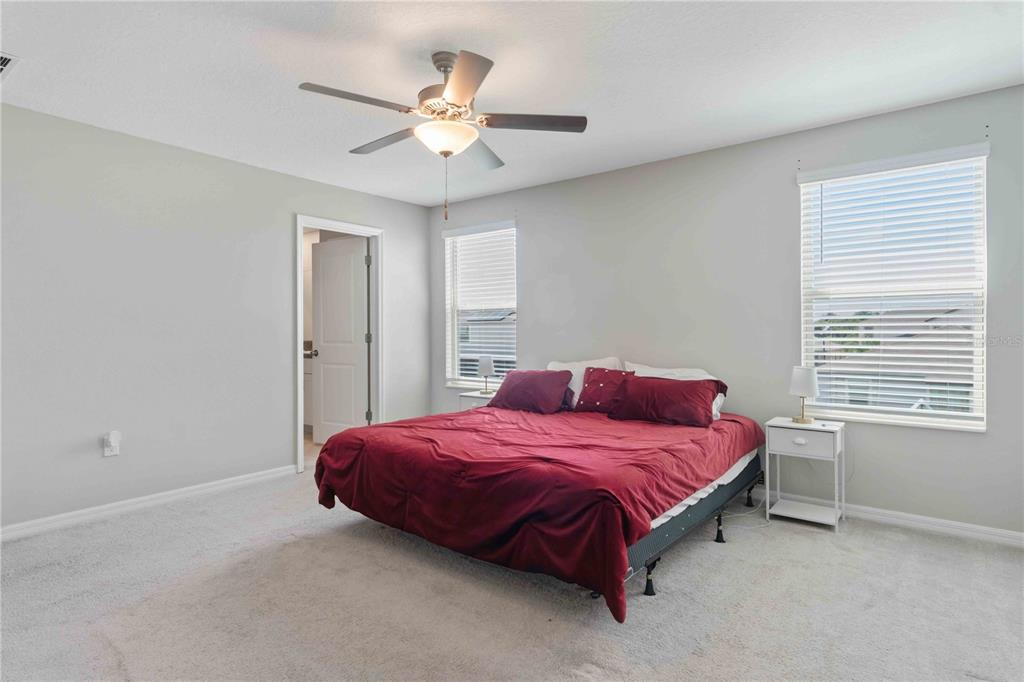 9440 Lemon Drop Loop Sun City Center, FL 33573 - Photo 31 of 55 a bedroom with a bed and a ceiling fan