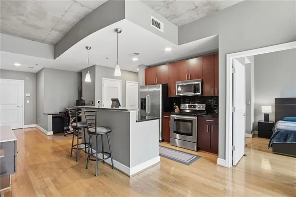 a open kitchen with kitchen island a large counter top stainless steel appliances and cabinets