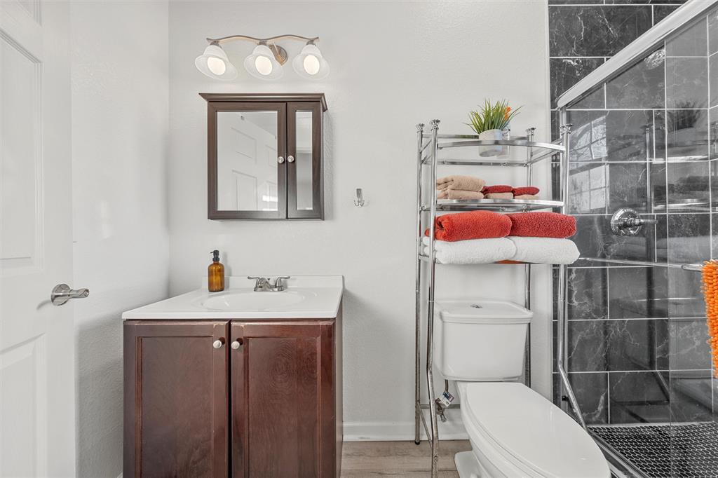 1200 North 15th Street Waco, TX 76707 - Photo 14 of 19 a bathroom with a toilet sink vanity and mirror