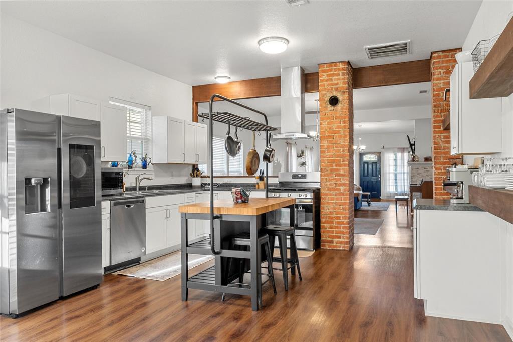 1200 North 15th Street Waco, TX 76707 - Photo 6 of 19 a kitchen with stainless steel appliances granite countertop a table chairs refrigerator and a stove
