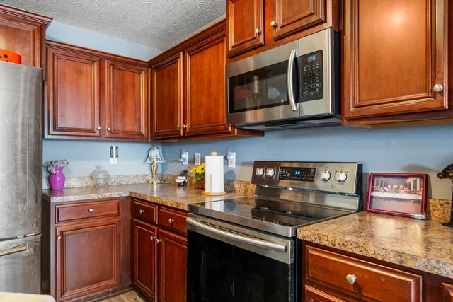 a kitchen with stainless steel appliances granite countertop a sink stove and cabinets