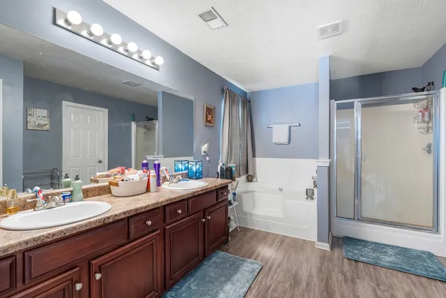 a spacious bathroom with a double vanity sink a mirror and a shower