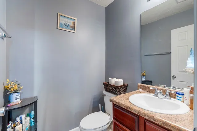 a bathroom with a granite countertop toilet sink and mirror
