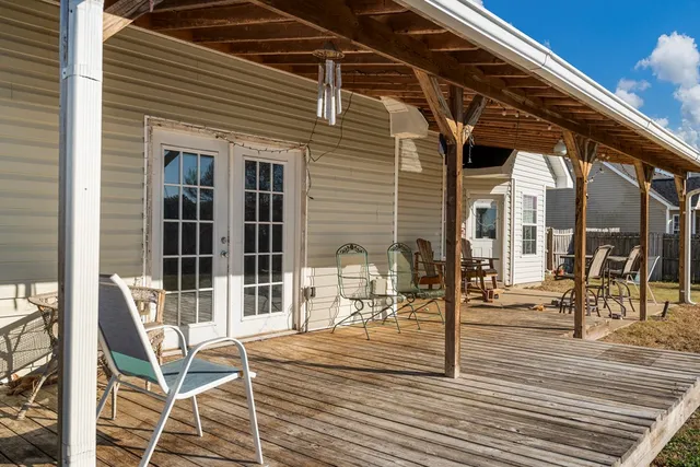 a patio with table and chairs and potted plants