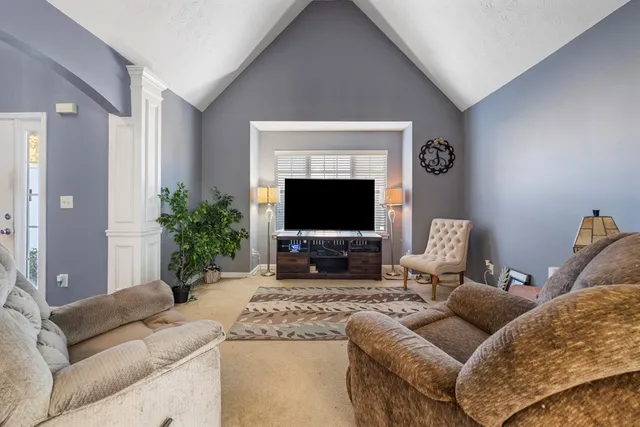 a living room with furniture a flat screen tv and a fireplace