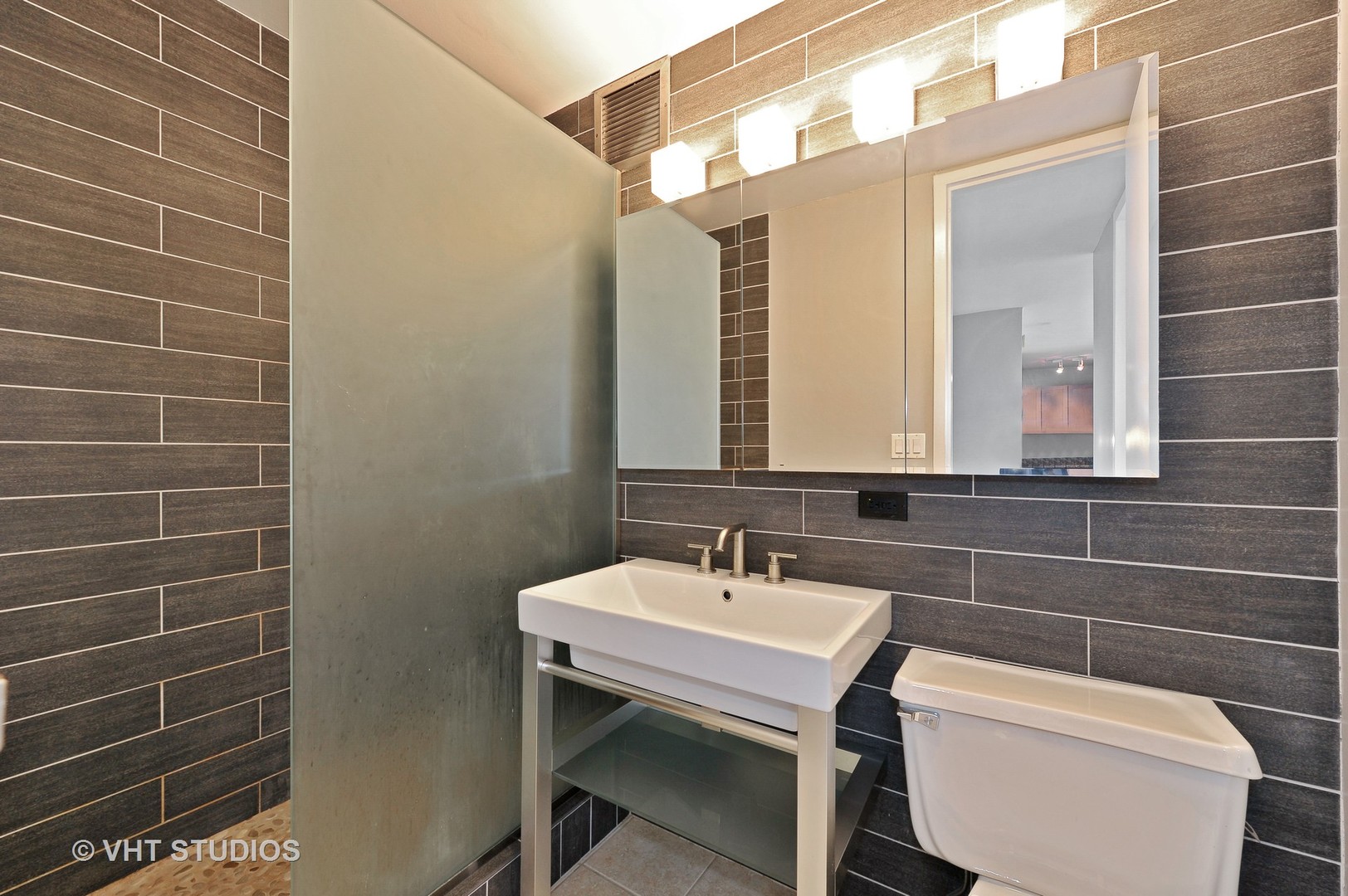 655 West Irving Park Road, Unit 2106 Chicago, IL 60613 - Photo 14 of 15 a bathroom with a toilet a sink and mirror