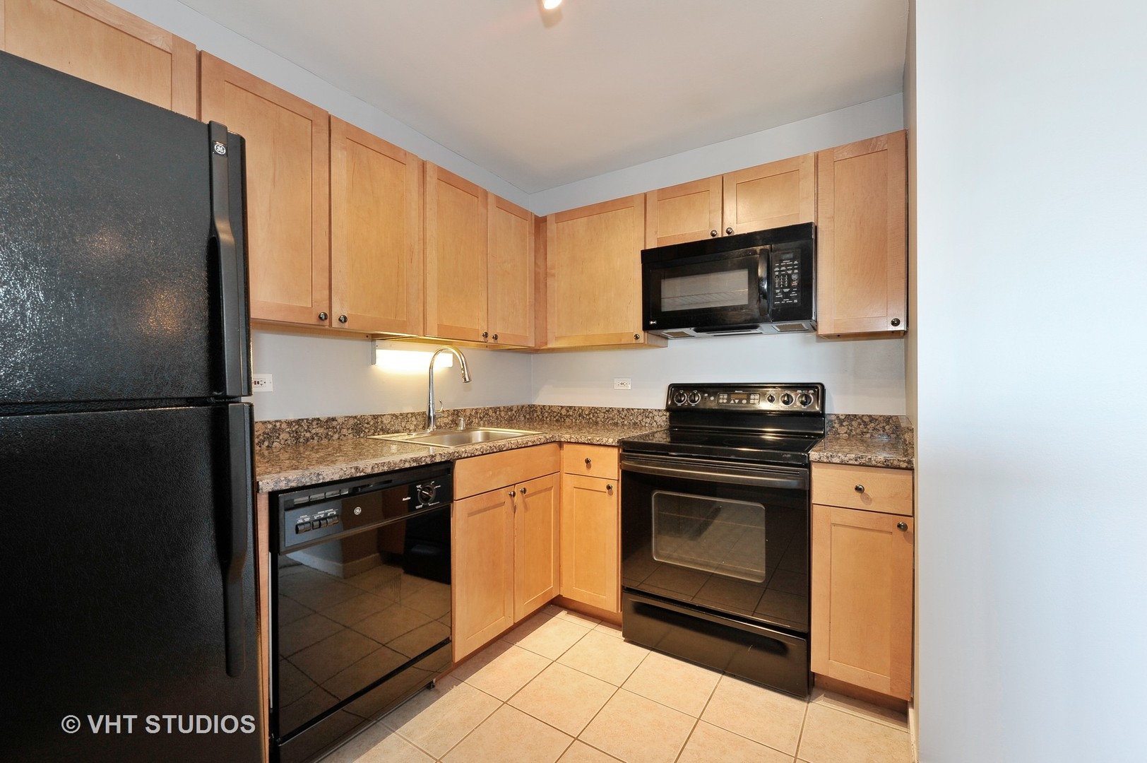 655 West Irving Park Road, Unit 2106 Chicago, IL 60613 - Photo 9 of 15 a kitchen with stainless steel appliances granite countertop a stove a sink and a microwave