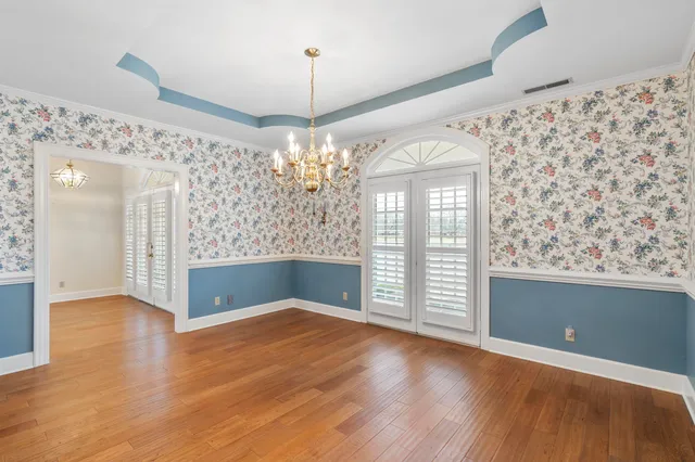 a view of a livingroom with wooden floor and chandelier