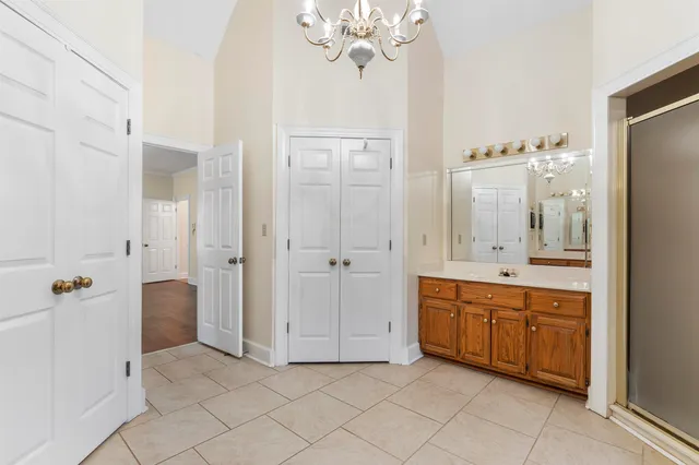 a spacious bathroom with a double vanity sink a large mirror and a shower