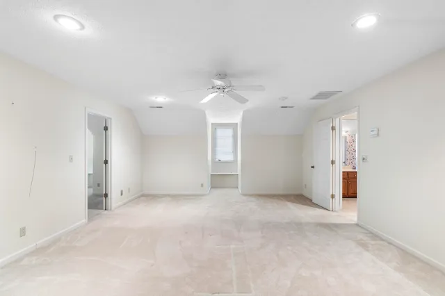 an empty room with a ceiling fan and window