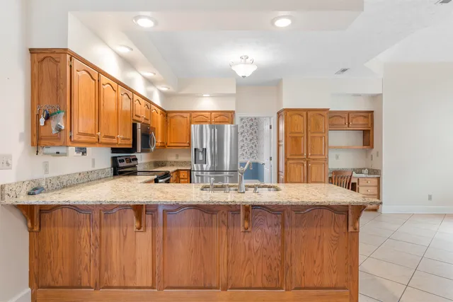 a kitchen with stainless steel appliances granite countertop a sink a stove counter space and cabinets