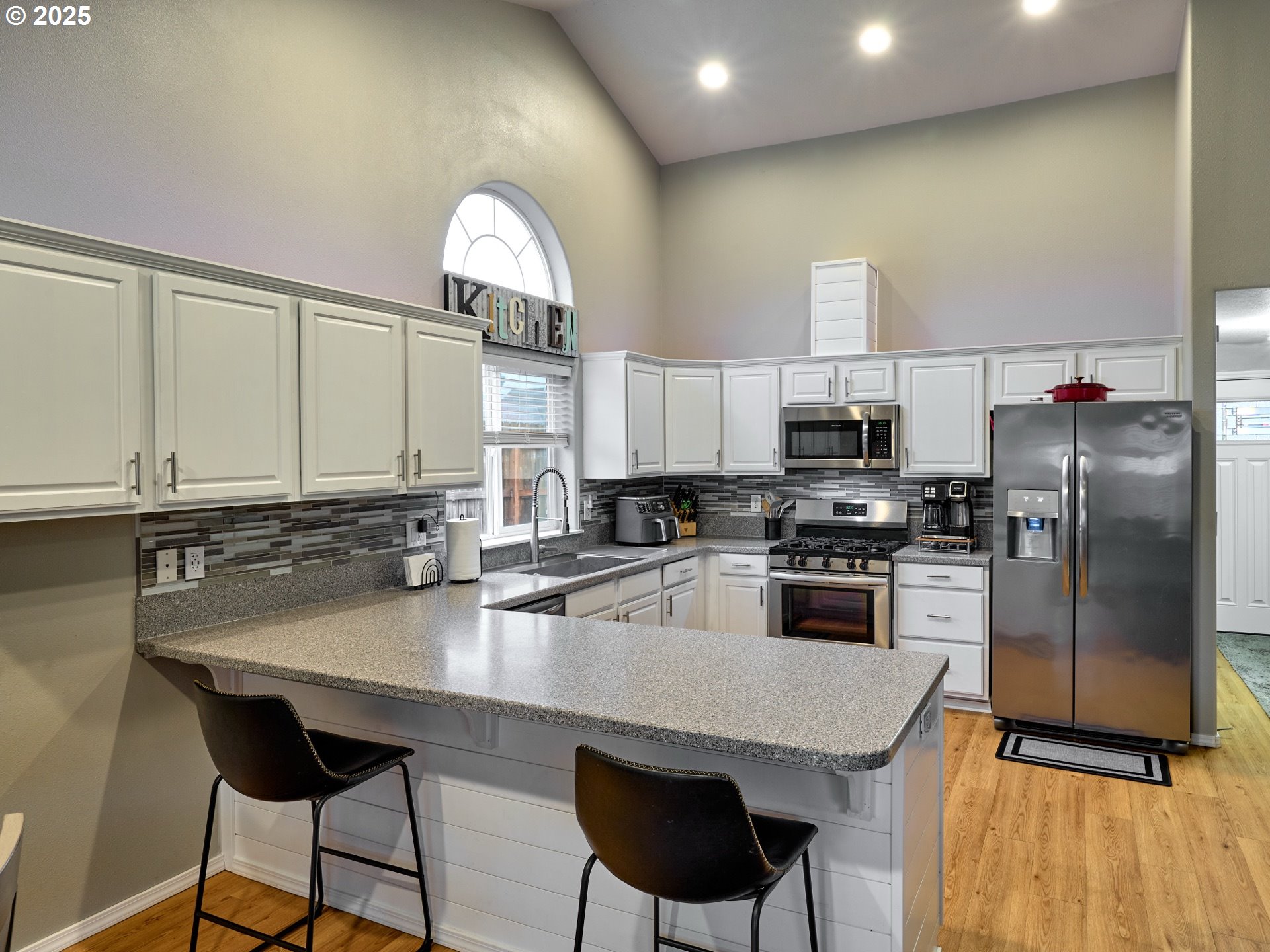 1353 Jodi Drive Silverton, OR 97381 - Photo 14 of 48 a kitchen with stainless steel appliances granite countertop a sink a stove a refrigerator cabinets and a dining table with wooden floor