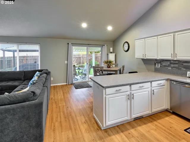a view of a kitchen counter top space with wooden floor and furniture