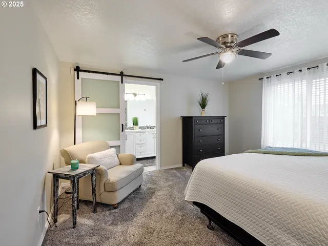 a spacious bedroom with a bed a couch and a window