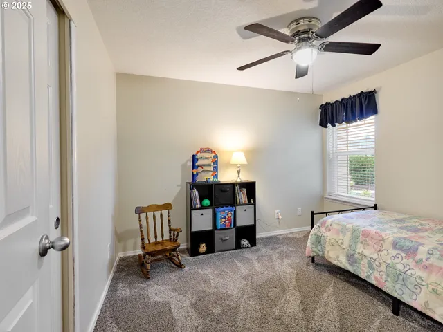a bedroom with a bed a chandelier and a window