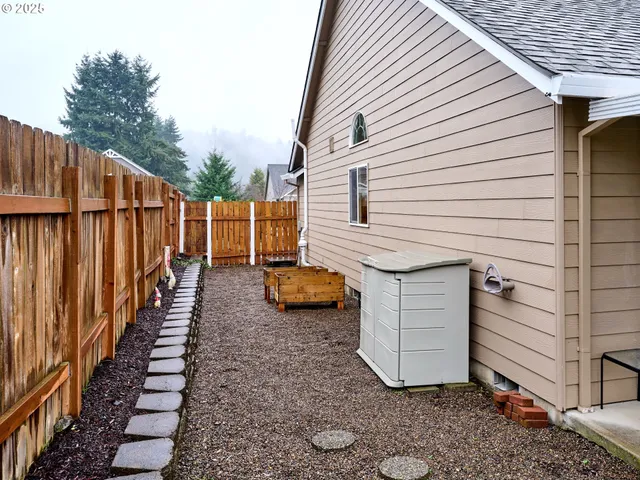 a view of a house with backyard and wooden fence