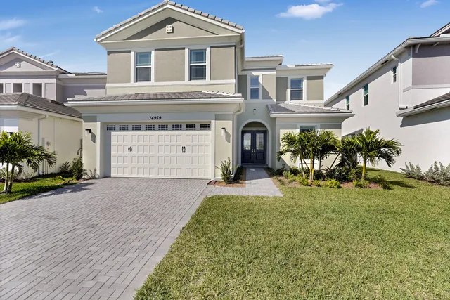 a front view of a house with a yard and garage
