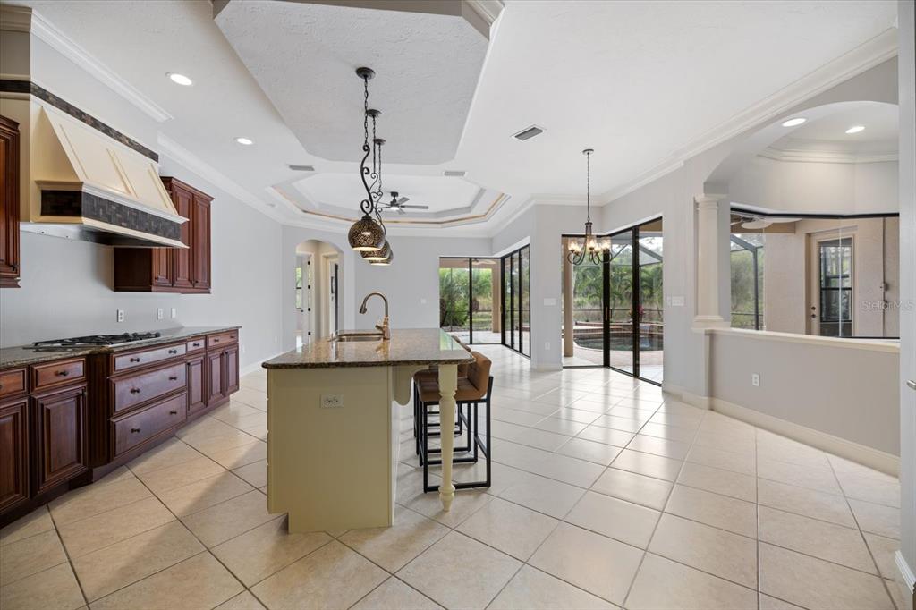 616 Crane Prairie Way Osprey, FL 34229 - Photo 11 of 54 a large kitchen with stainless steel appliances granite countertop a stove and a view of living room