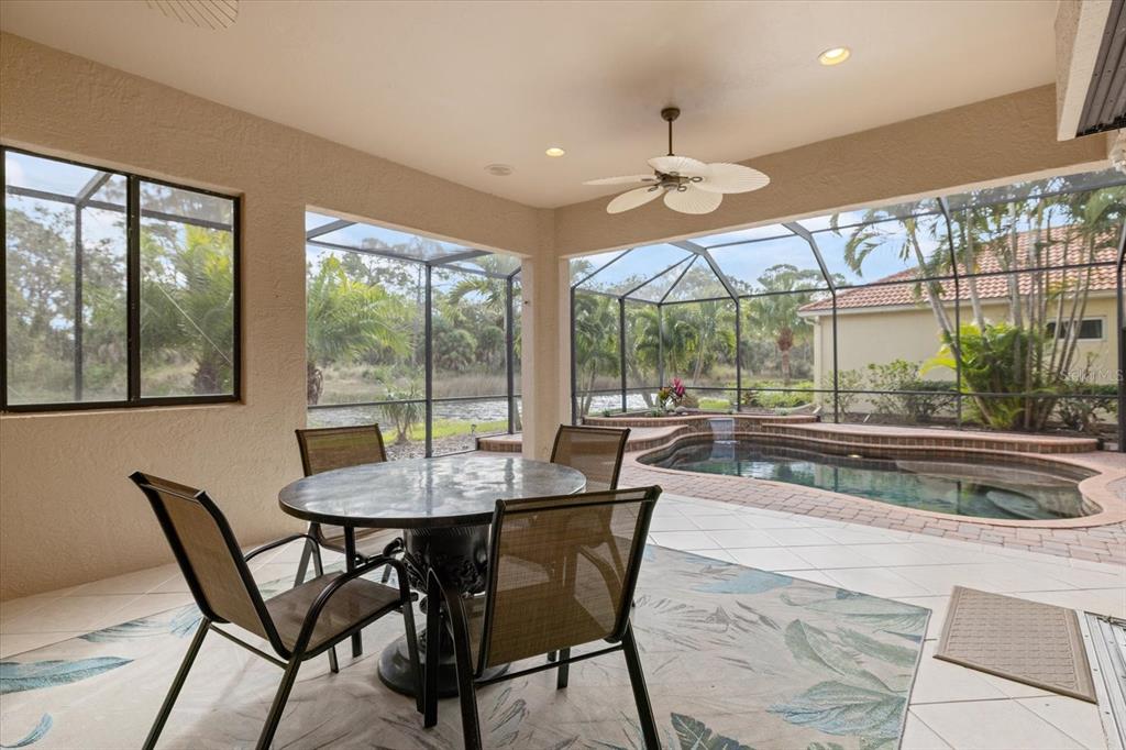 616 Crane Prairie Way Osprey, FL 34229 - Photo 44 of 54 a dining room with wooden floor a chandelier a glass table and chairs