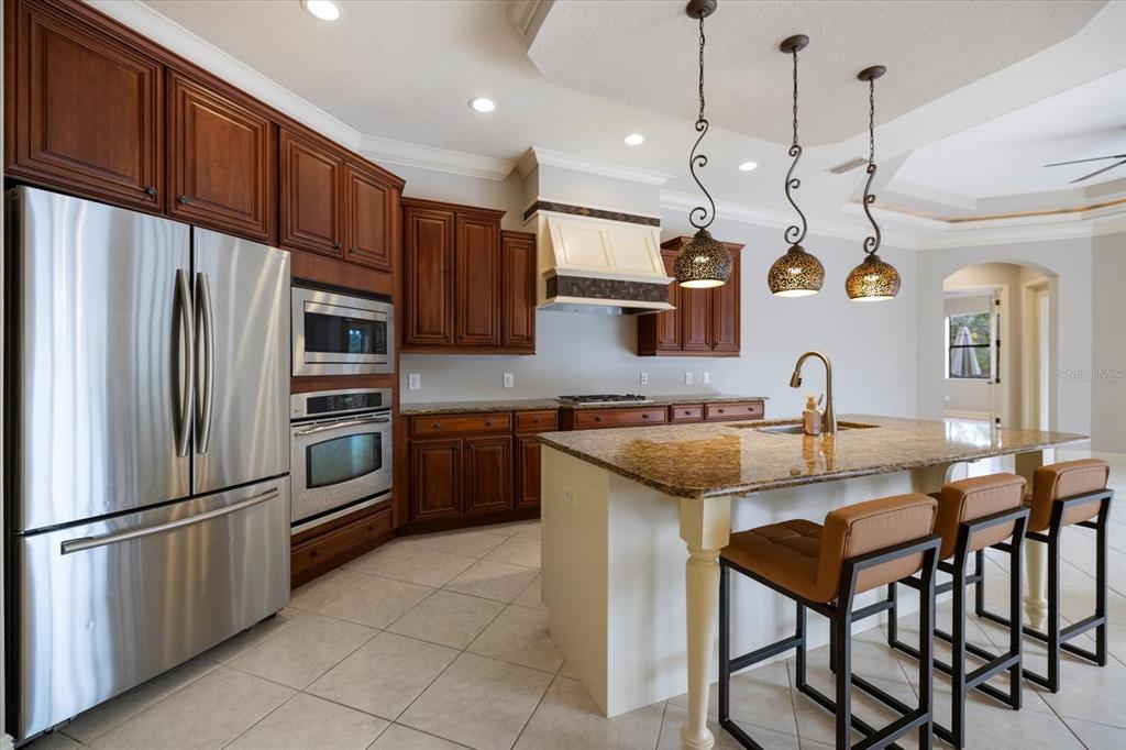 616 Crane Prairie Way Osprey, FL 34229 - Photo 10 of 54 a kitchen with stainless steel appliances granite countertop a sink a stove a refrigerator and island