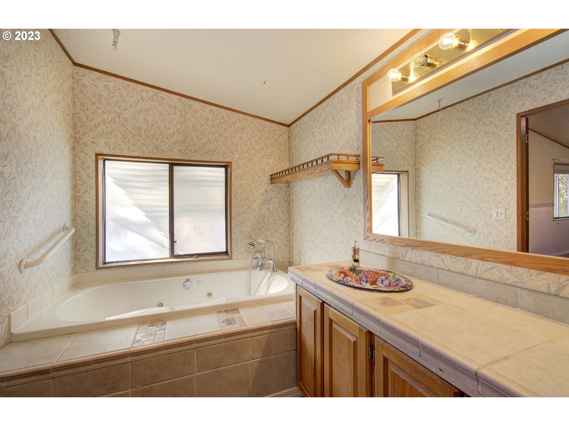 15619 Northeast Caples Road Brush Prairie, WA 98606 - Photo 19 of 27 a bathroom with a granite countertop sink mirror and a bathtub