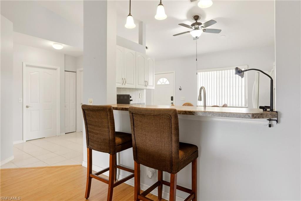 1723 Reuven Circle, Unit 2004 Naples, FL 34112 - Photo 11 of 29 a kitchen with a table chairs and cabinets