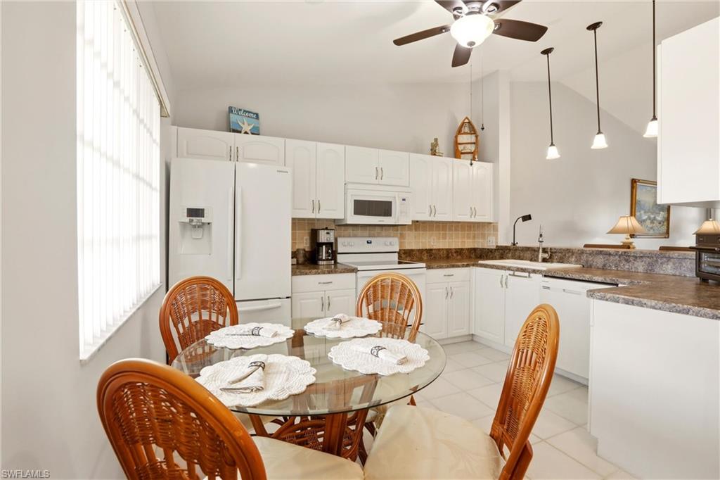 1723 Reuven Circle, Unit 2004 Naples, FL 34112 - Photo 12 of 29 a kitchen with stainless steel appliances granite countertop a dining table and chairs