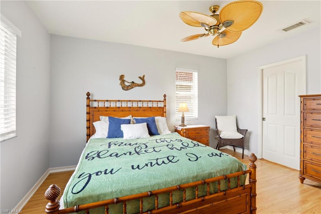 1723 Reuven Circle, Unit 2004 Naples, FL 34112 - Photo 19 of 29 a bedroom with a bed and a chandelier