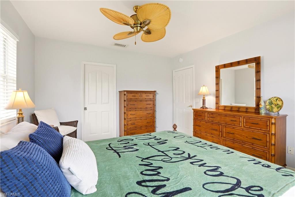 1723 Reuven Circle, Unit 2004 Naples, FL 34112 - Photo 20 of 29 a bedroom with a bed and dresser with mirror